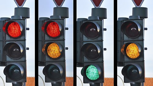 Fyra trafikljus med rött, gult och grönt ljus i olika kombinationer
