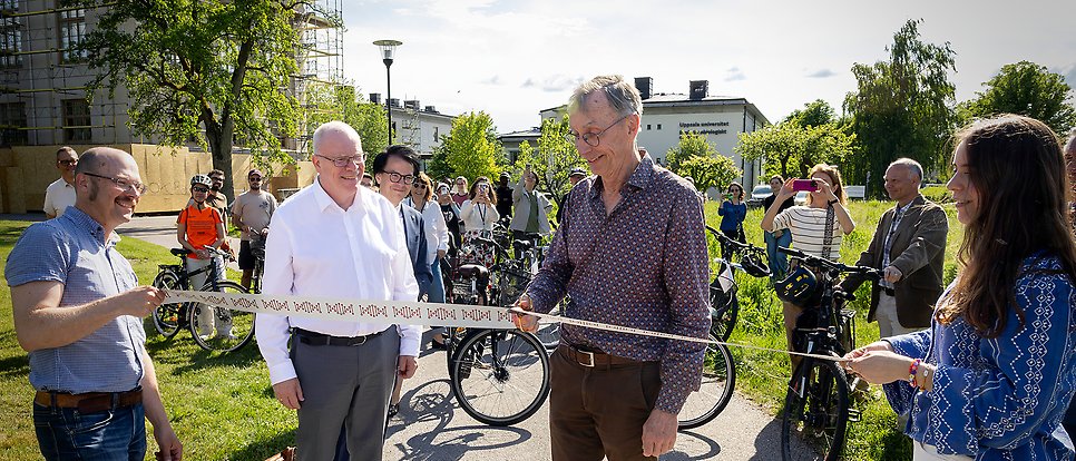Svante Pääbo cuts the ribbon, surrounded by people.