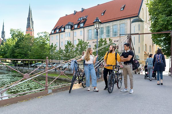Students talking with eachother on a summers day with Uppsala Cathedral in the background